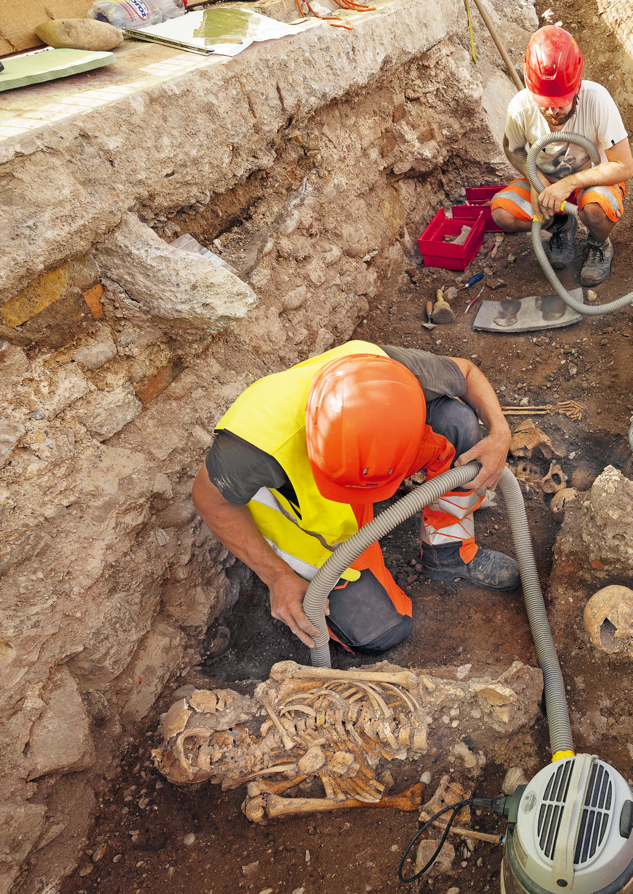 Mitarbeitende der Archäologischen Bodenforschung reinigen Skelette bei den Grabungen unter dem Martinskirchplatz.